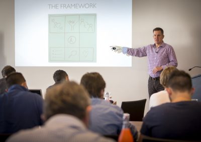 David Jenyns presenting The Framework slide to a seated audience at a SYSTEMology workshop or seminar