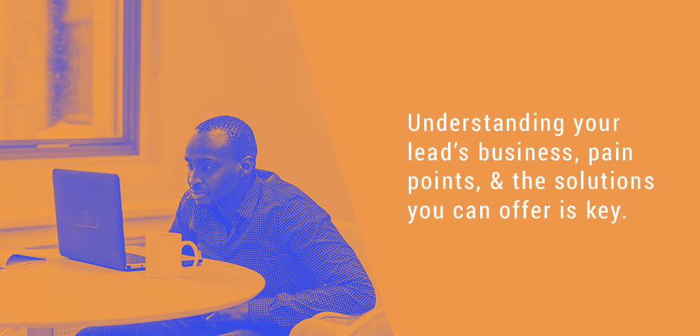 Man researching at a laptop beside the words understanding your lead's business, pain points and the solutions you can offer is key
