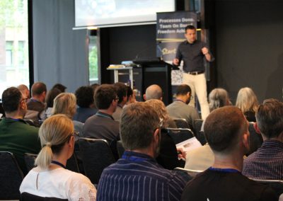 David Jenyns presenting at a SYSTEMology business summit to a full audience in a conference venue